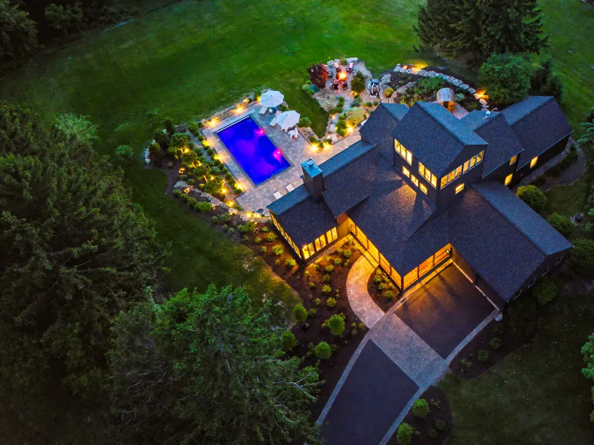 Aerial view of Tower House at night with the pool lit