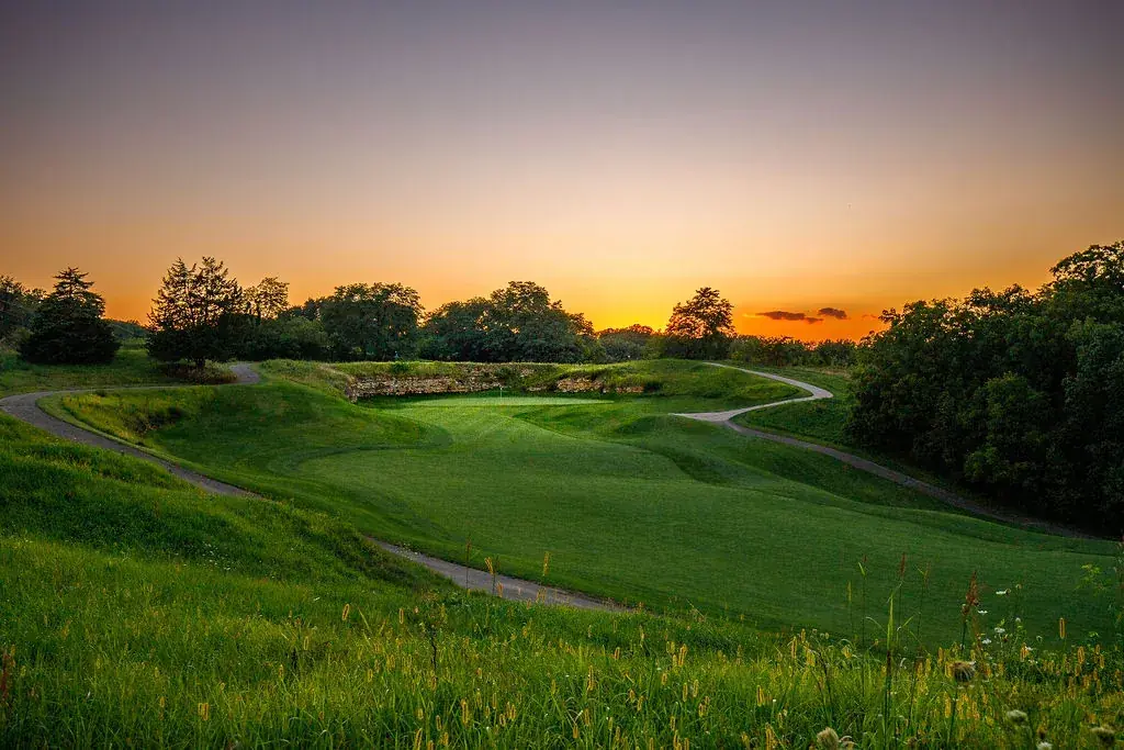 A golf green at sunset in the hills